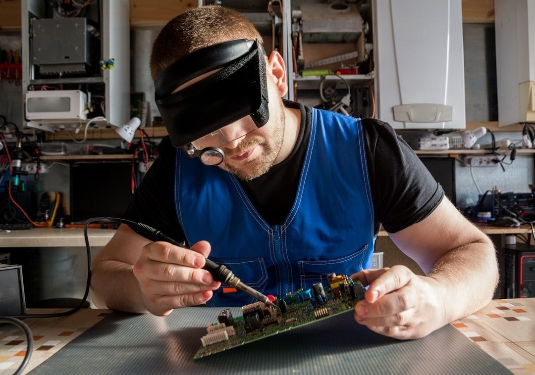 Tekniker testar ett kretskort med lödkolv i elektronikverkstad